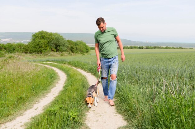 Vue de face mâle adulte se promener avec son chien