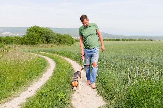 Vue de face mâle adulte se promener avec son chien