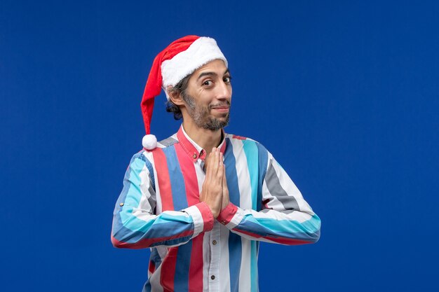 Vue de face mâle régulier avec bonnet de noël rouge priant, vacances de noël du père noël