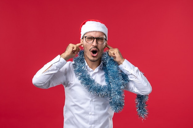 Photo gratuite vue de face mâle régulier célébrant le nouvel an sur le mur rouge vacances humaines de noël