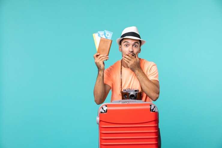 Photo gratuit vue de face mâle en vacances tenant ses billets sur bleu