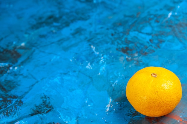 Vue de face mandarine fraîche sur la table bleue