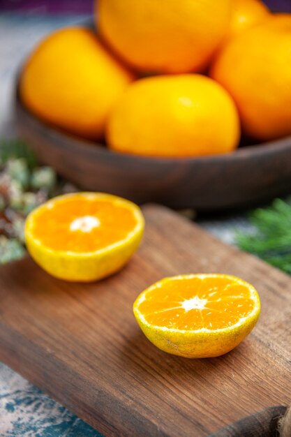 Vue de face des mandarines fraîches sur une table bleu clair