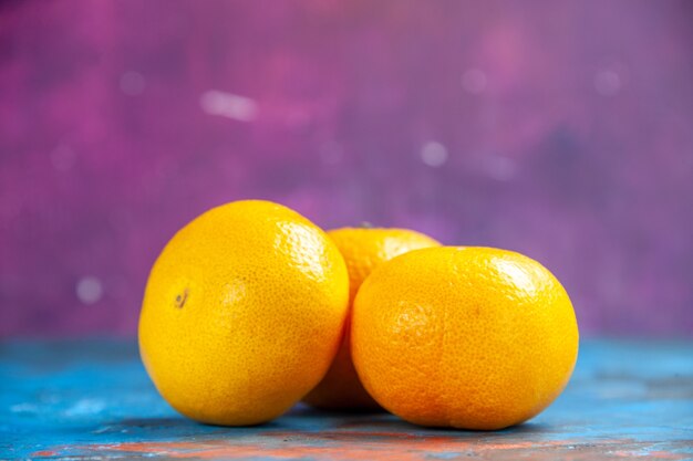 Vue de face des mandarines fraîches sur une table bleu-violet