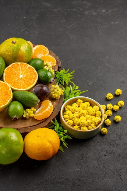 Photo gratuite vue de face mandarines vertes fraîches avec feijoas sur bureau sombre agrumes fruits exotiques verts frais mûrs