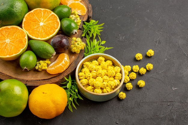 Vue de face mandarines vertes fraîches avec feijoas sur l'espace sombre