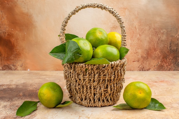 Vue de face mandarines vertes fraîches à l'intérieur du panier sur fond clair jus de fruits moelleux couleur de Noël