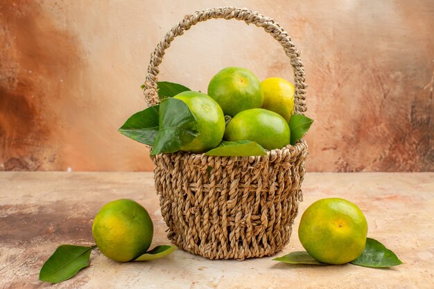 Vue de face mandarines vertes fraîches à l'intérieur du panier sur fond clair jus de fruits moelleux couleur de Noël