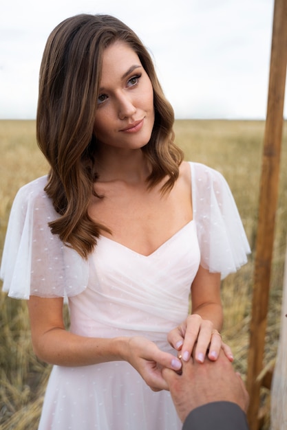 Vue de face mariée souriante à l'extérieur