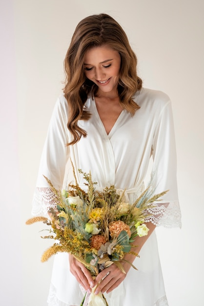 Photo gratuite vue de face mariée souriante tenant des fleurs