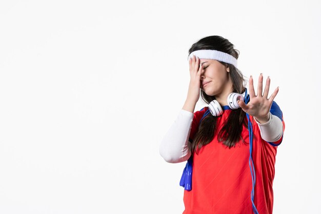 Vue de face mécontent de la jeune femme en vêtements de sport avec des cordes à sauter