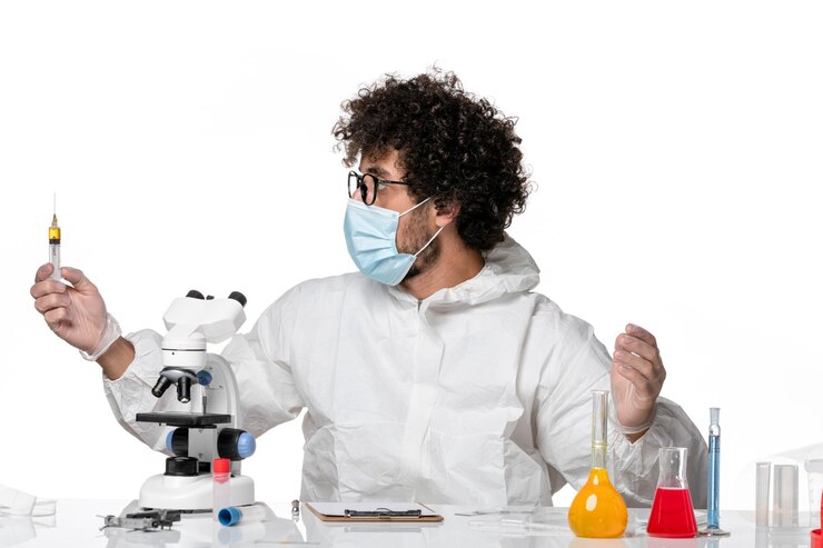 Photo gratuit vue de face médecin de sexe masculin en tenue de protection et masque tenant l'injection sur blanc