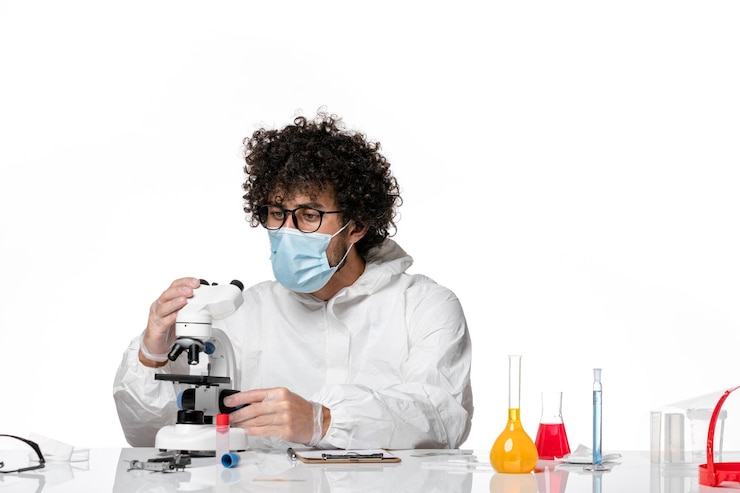 Photo gratuit vue de face médecin de sexe masculin en tenue de protection et masque tenant l'injection sur blanc