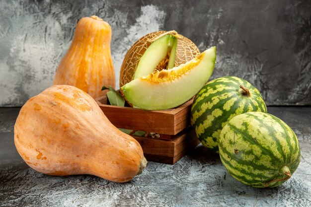 Vue de face de melon frais avec de la citrouille et de la pastèque sur le fond sombre