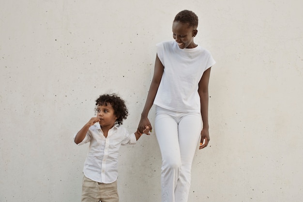 Vue de face mère et enfant se tenant la main