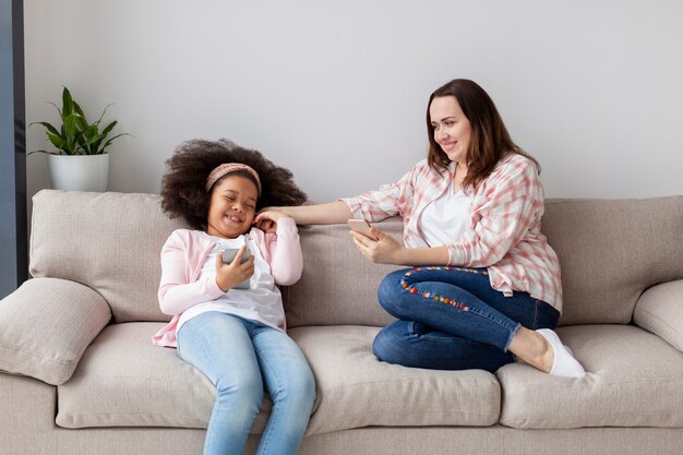 Vue de face mère et fille se détendre à la maison