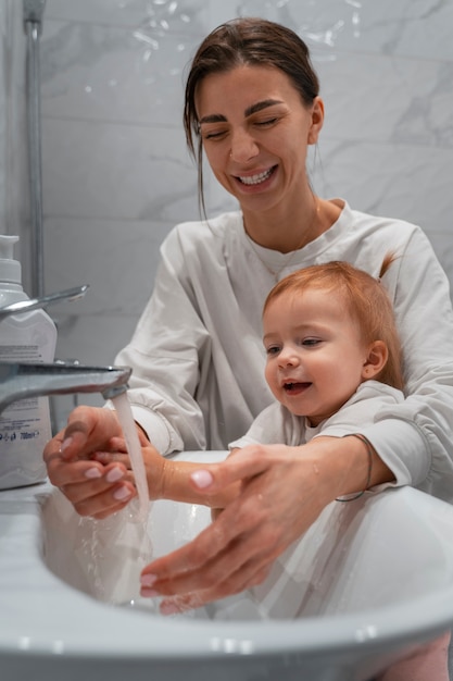 Photo gratuite vue de face mère lavant bébé