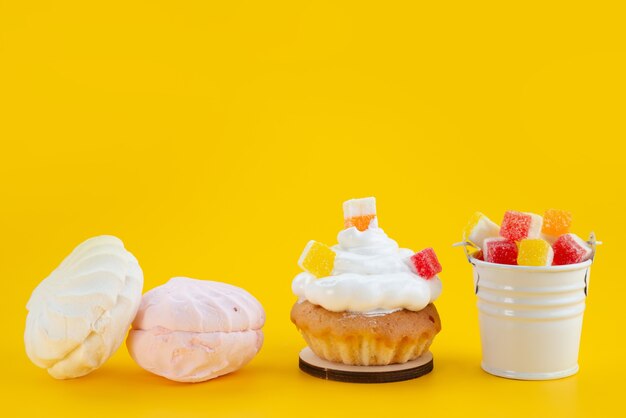 Une vue de face meringues et marmelade délicieux et sucré sur jaune, biscuit gâteau au sucre