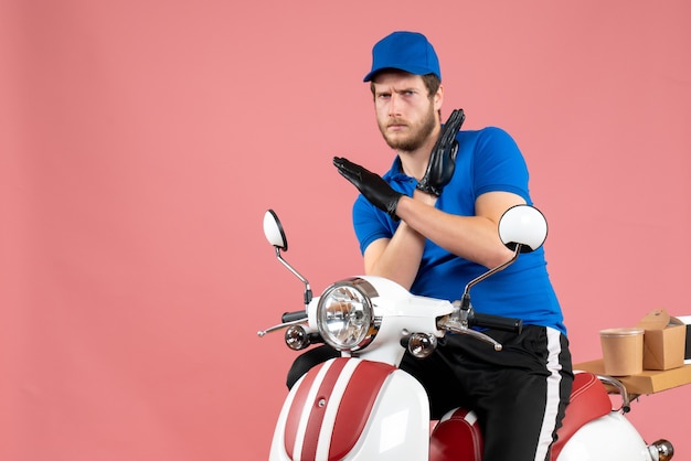 Vue de face messager masculin en uniforme bleu sur un travail de livraison de vélo de couleur de service de restauration rapide de nourriture rose