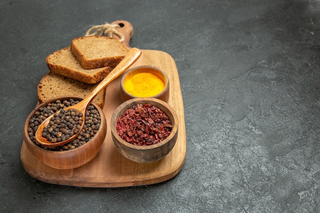 Vue de face des miches de pain avec des assaisonnements sur fond gris épicé repas pain épicé