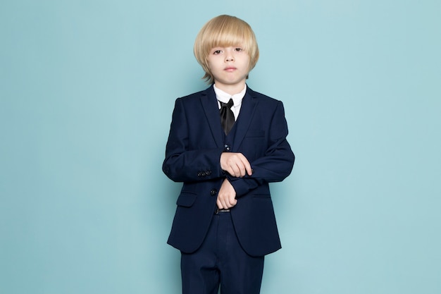 Une vue de face mignon garçon d'affaires en costume classique bleu posant la mode de travail d'entreprise