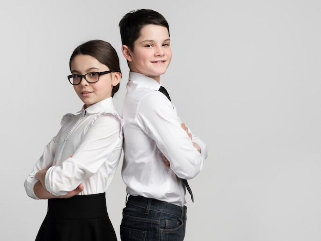 Vue de face mignon jeune garçon et fille posant ensemble