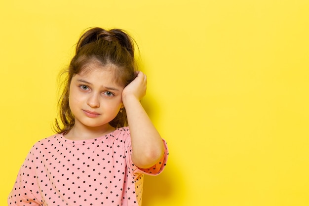 Une vue de face mignon petit enfant en robe rose pleurer