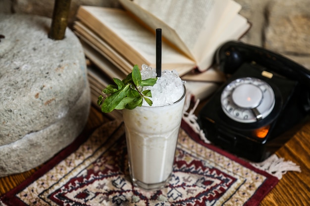 Vue de face milkshake à la menthe et paille sur la table