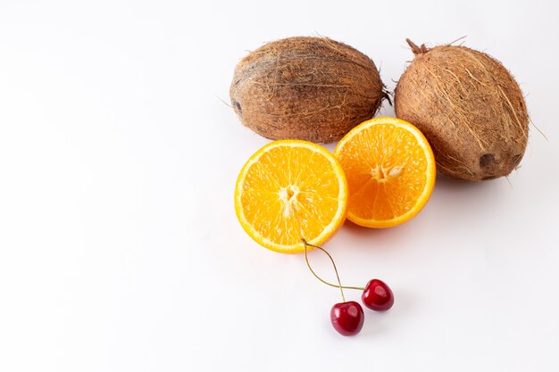 Vue de face de noix de coco fraîches avec des tranches d'orange sur blanc