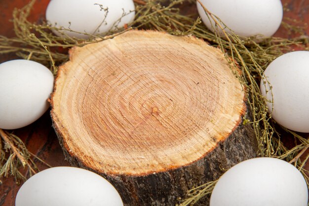 Vue de face des œufs de poule blancs sur la surface sombre