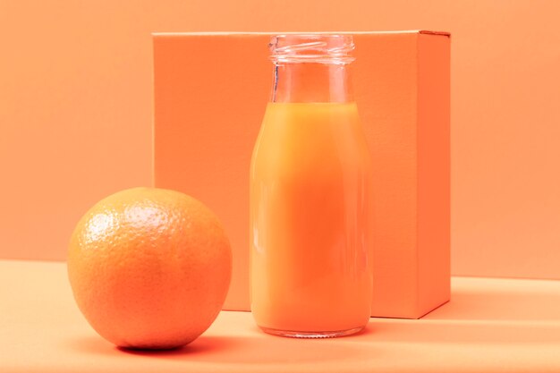 Vue de face orange et smoothie en bouteille