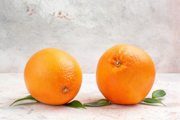 Vue de face des oranges fraîches sur fond isolé lumineux avec espace de copie