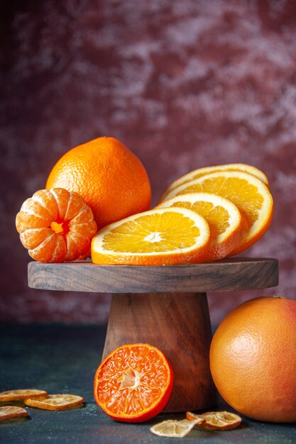 Vue de face oranges fraîches sur le fond sombre fruit couleur d'agrumes jus mûr d'agrumes goût d'arbre moelleux