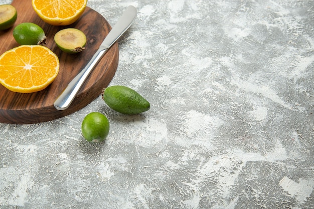 Vue de face oranges fraîches tranchées avec feijoa sur fond blanc fruits mûrs exotiques frais tropicaux