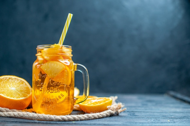 Vue de face des oranges et des pommes coupées en cocktail sur planche de bois sur fond isolé sombre