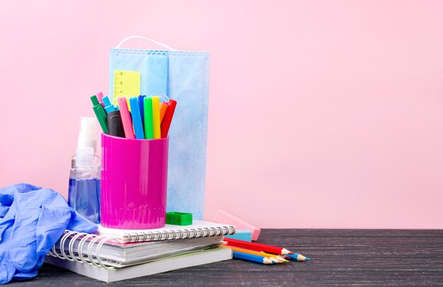 Vue de face de la papeterie de retour à l'école avec des crayons et des cahiers