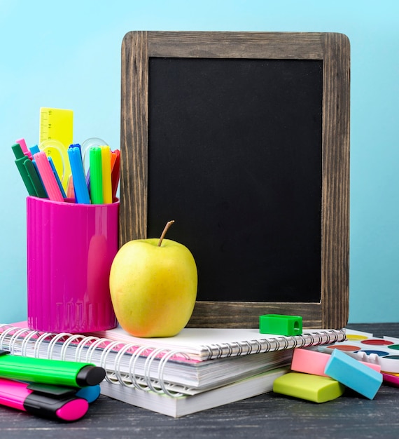 Vue de face de la papeterie de retour à l'école avec des crayons et pomme