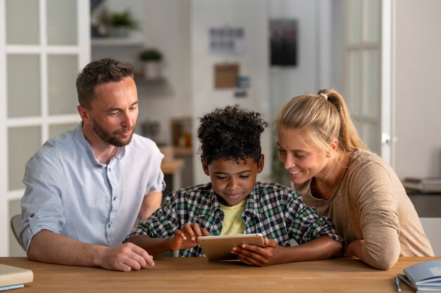 Vue de face parents et enfant avec tablette