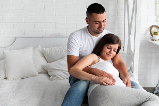 Vue de face des parents heureux en attente d'un nouveau membre de la famille