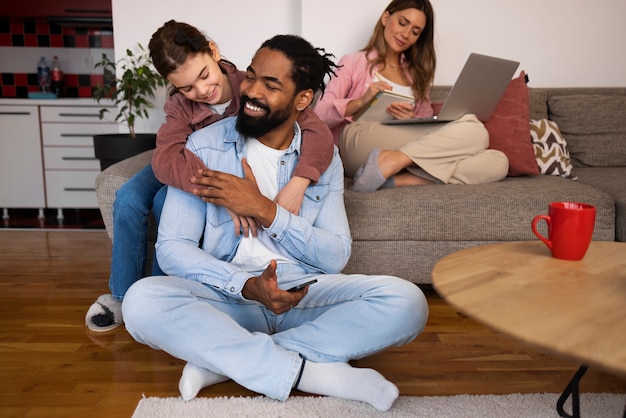 Vue de face parents heureux avec enfant à la maison