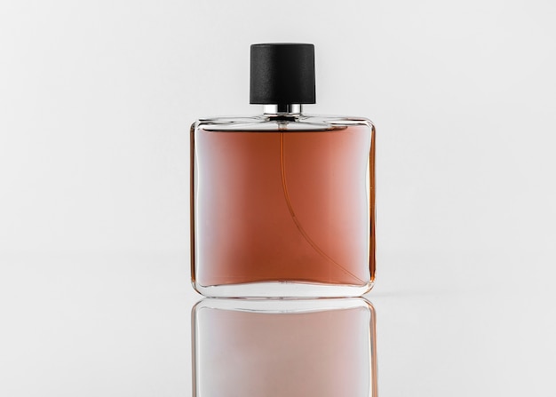 Une vue de face parfum brun conçu avec un capuchon noir sur le bureau blanc