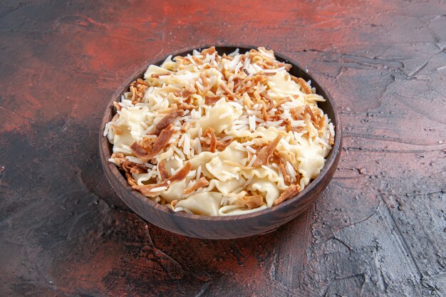 Vue de face de la pâte cuite en tranches avec du riz sur une surface sombre plat de pâte de pâte repas de pâtes