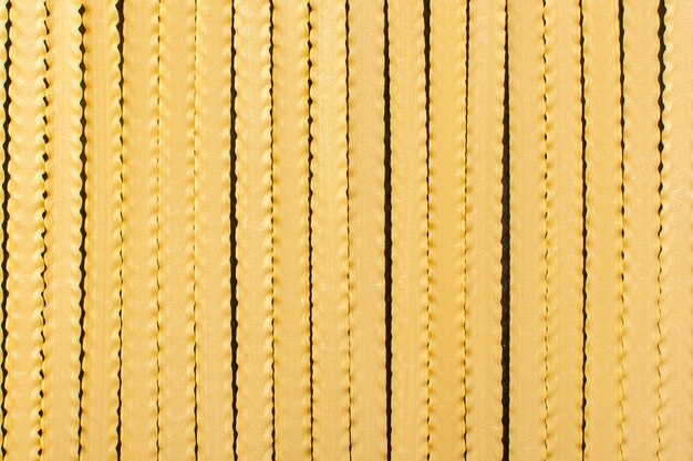 Une vue de face de pâtes longues jaunes formées crues alimentaires de pâtes italiennes crues