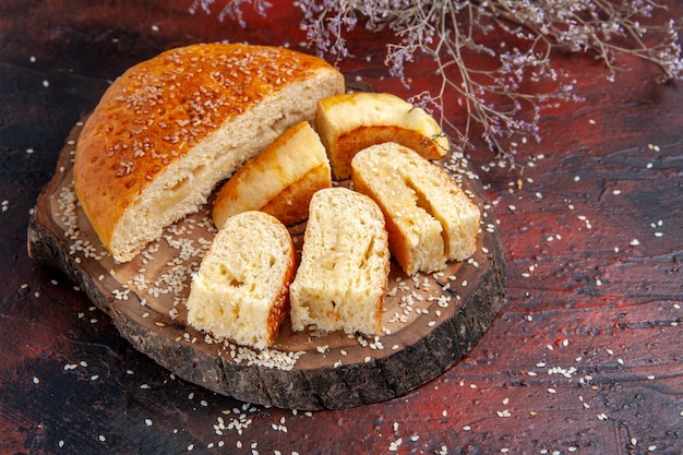 Vue de face de la pâtisserie sucrée coupée en morceaux sur le fond sombre