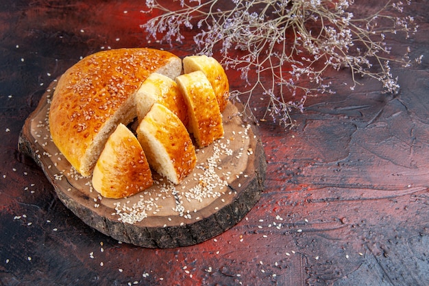 Vue de face de la pâtisserie sucrée coupée en morceaux sur le fond sombre