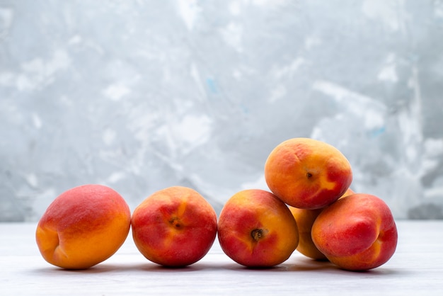 Une vue de face des pêches fraîches et moelleuses sur la couleur des fruits fond blanc