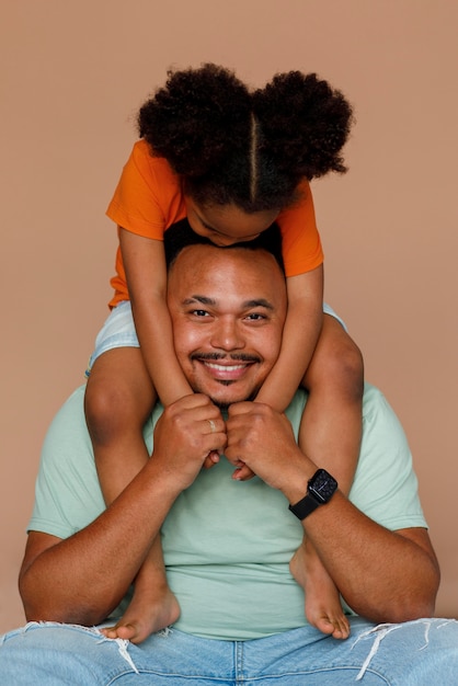 Photo gratuite vue de face père et fille posant en studio