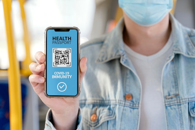 Vue de face d'une personne détenant un passeport de santé virtuel sur smartphone