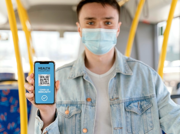 Vue de face d'une personne détenant un passeport de santé virtuel sur smartphone