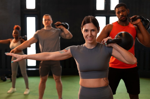 Photo gratuite vue de face des personnes s'entraînant ensemble au gymnase